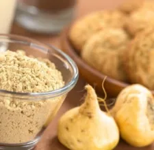 Maca roots with maca powder in a glass bowl